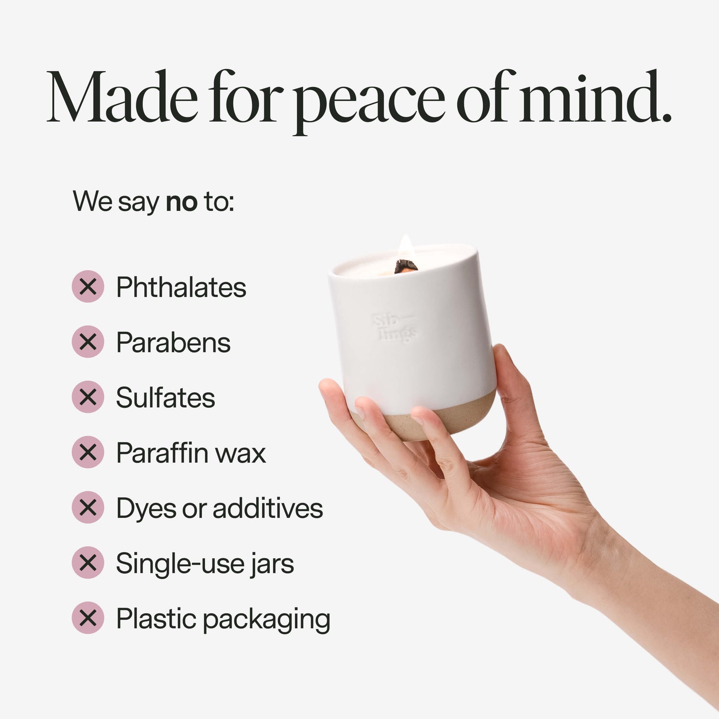 A hand holding a clean candle with text about product ingredients