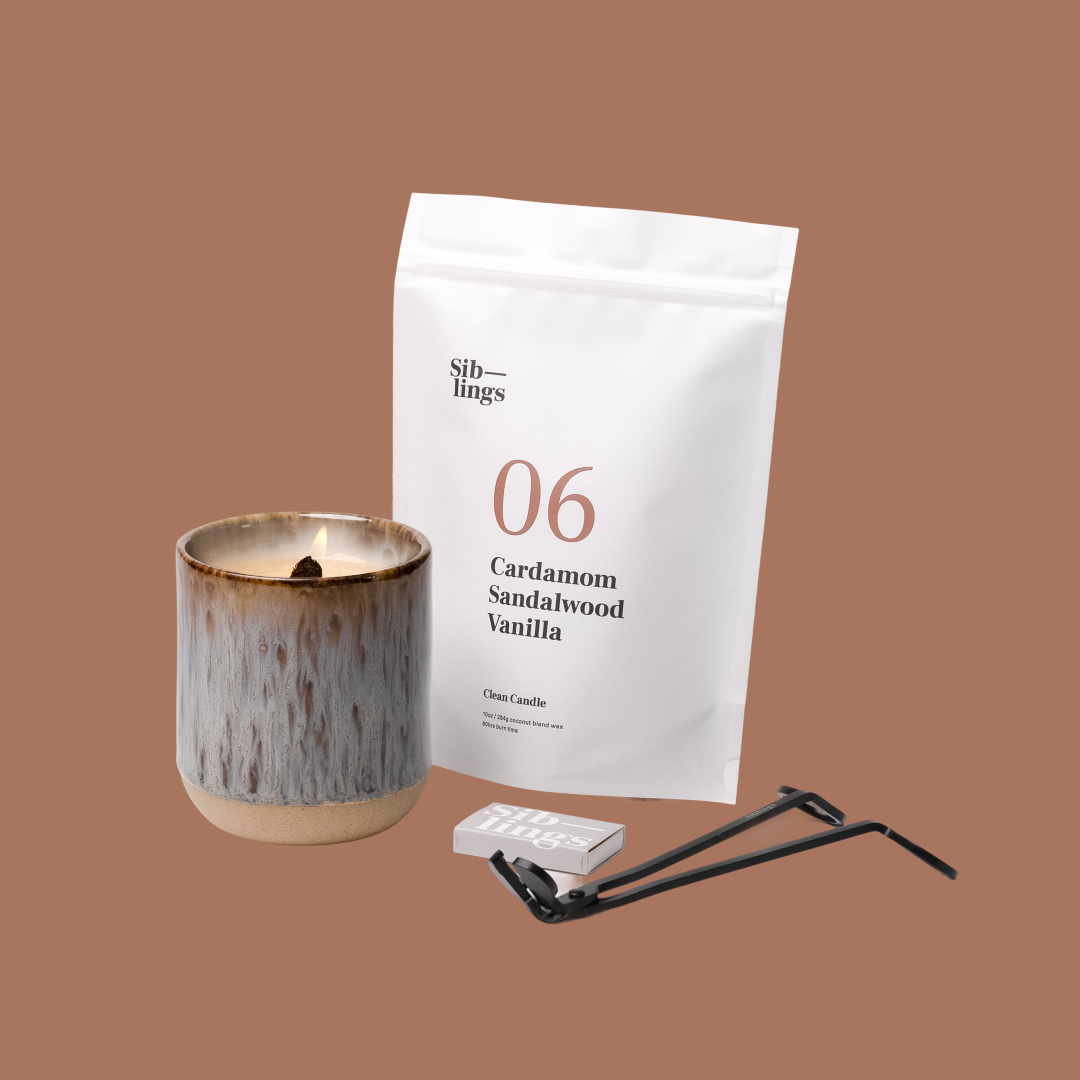 Siblings No. 06 candle starter set with Earth vessel, compostable wax refill bag (Cardamom, Sandalwood, Vanilla ), and black wick trimmer, showcasing an eco-friendly refill kit.