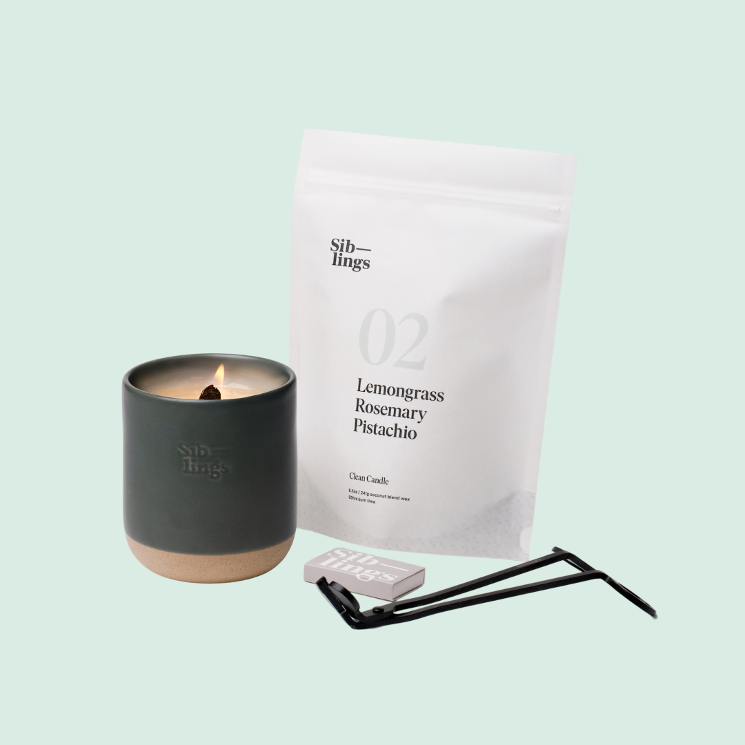 Siblings No. 02 candle starter set with Evergreen vessel, compostable wax refill bag (Lemongrass, Rosemary, Pistachio ), and black wick trimmer, showcasing an eco-friendly refill kit.