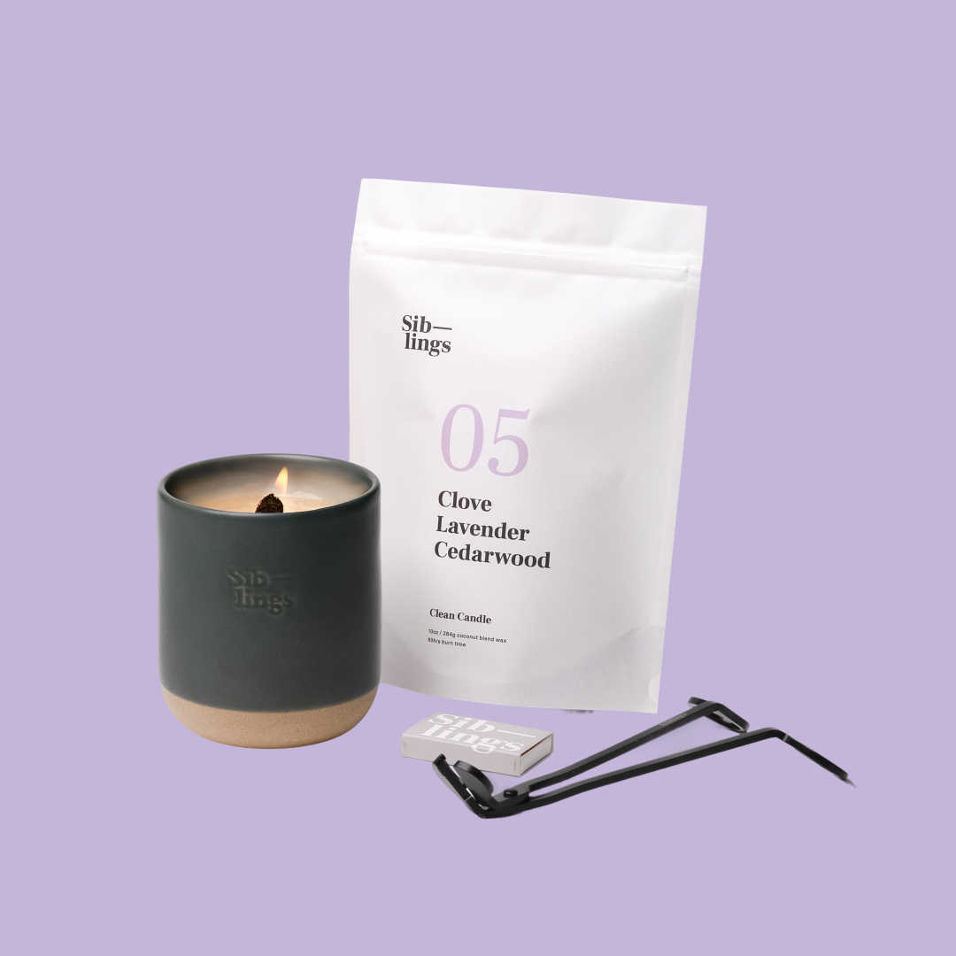 Siblings No. 05 candle starter set with Evergreen vessel, compostable wax refill bag (Clove, Lavender, Cedarwood ), and black wick trimmer, showcasing an eco-friendly refill kit.