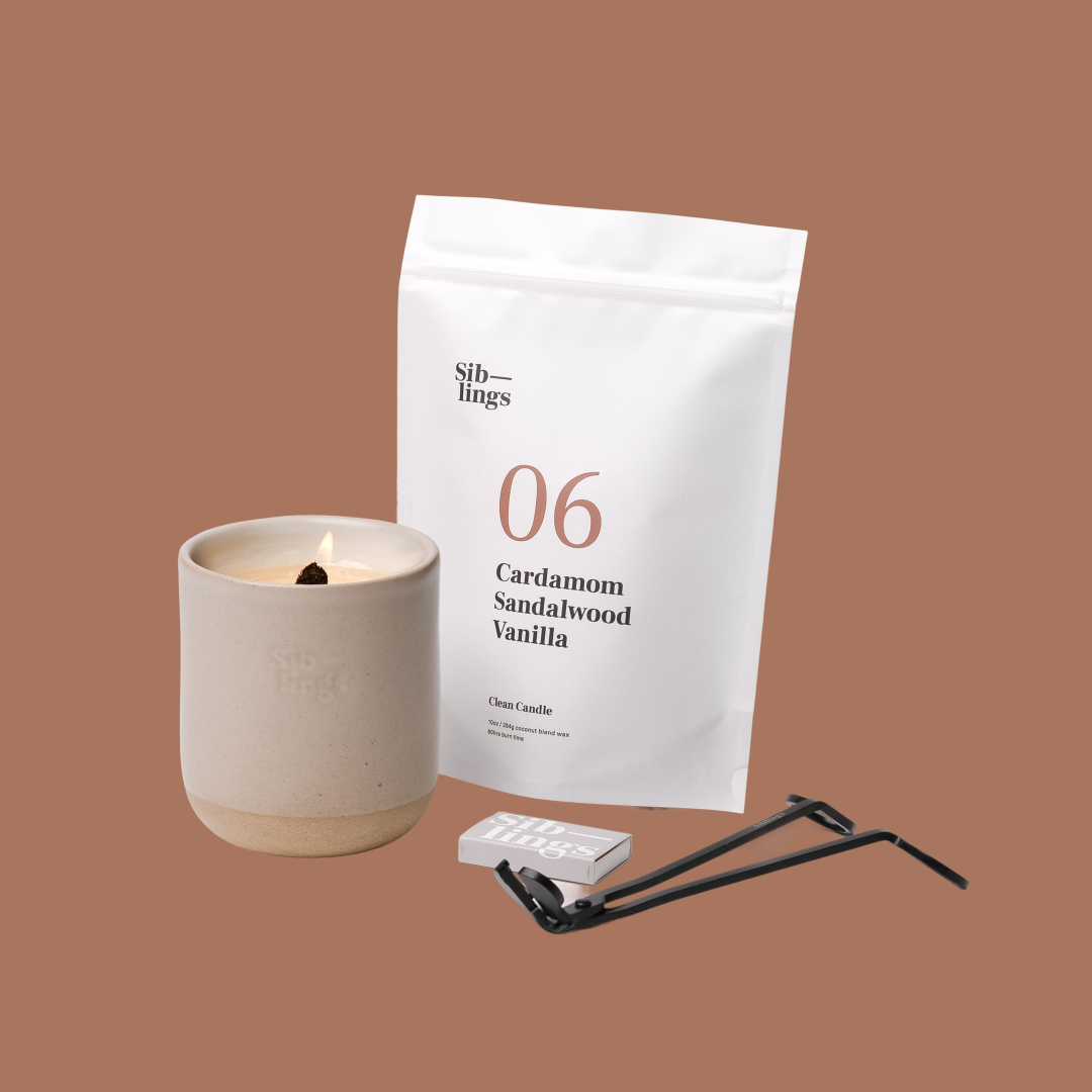Siblings No. 06 candle starter set with Sand vessel, compostable wax refill bag (Cardamom, Sandalwood, Vanilla ), and black wick trimmer, showcasing an eco-friendly refill kit.