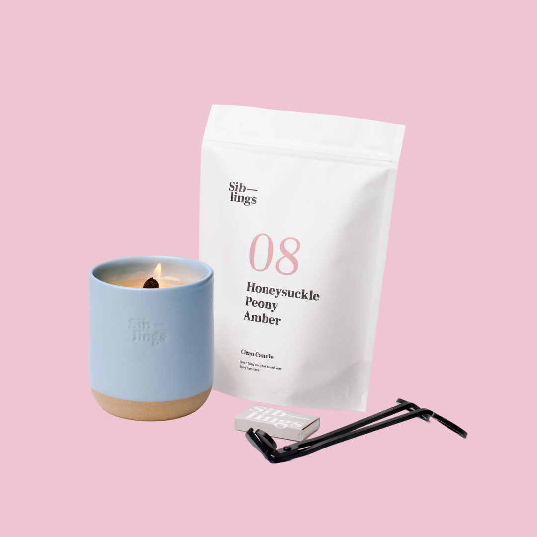 Siblings No. 08 candle starter set with Sky vessel, compostable wax refill bag (Peony, Honeysuckle, Amber), and black wick trimmer, showcasing an eco-friendly refill kit.